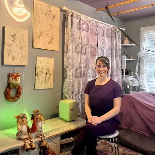 keri mills sitting and smiling in a massage room
